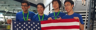 Students at the NACLO Open Competition, holding up an American flag and smiling