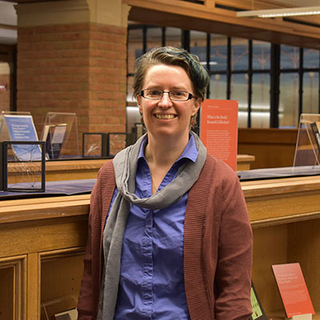 Claire Bowern stands in front of the Language is Everywhere! library collection